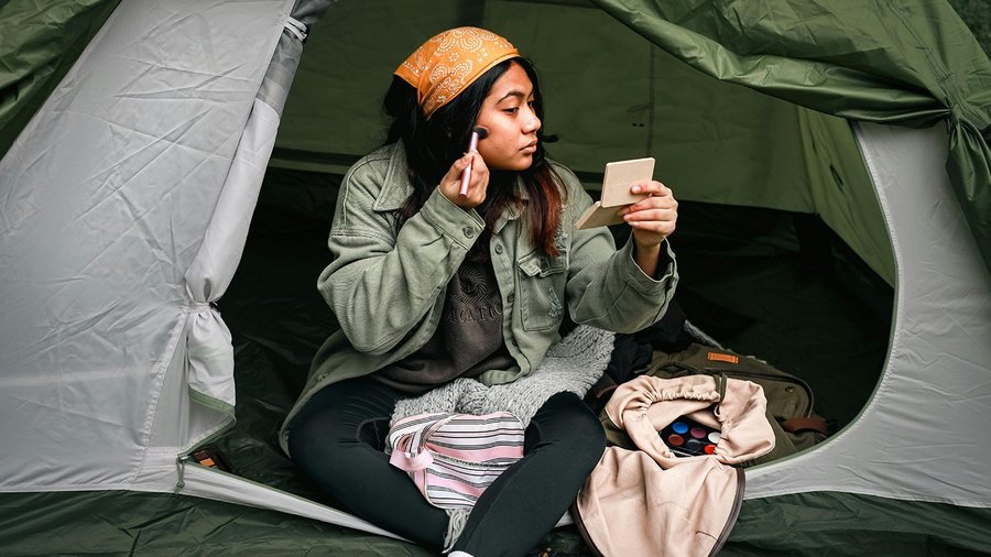 Une femme se maquille dans une tente