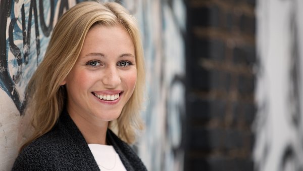 Solutions financières OVB Une femme blonde regarde devant elle en souriant.