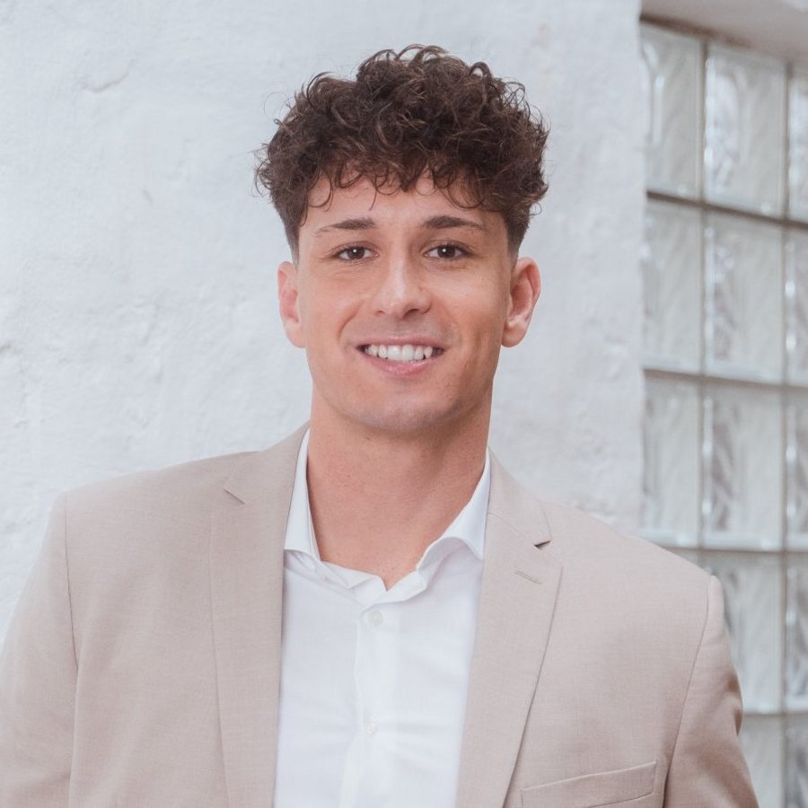 Trouver un conseiller OVB Un jeune homme en costume gris sourit aimablement à la caméra.