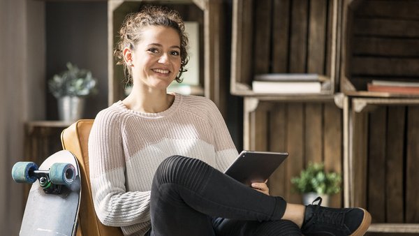 Jeune femme tient un cahier de comptes sur tablette